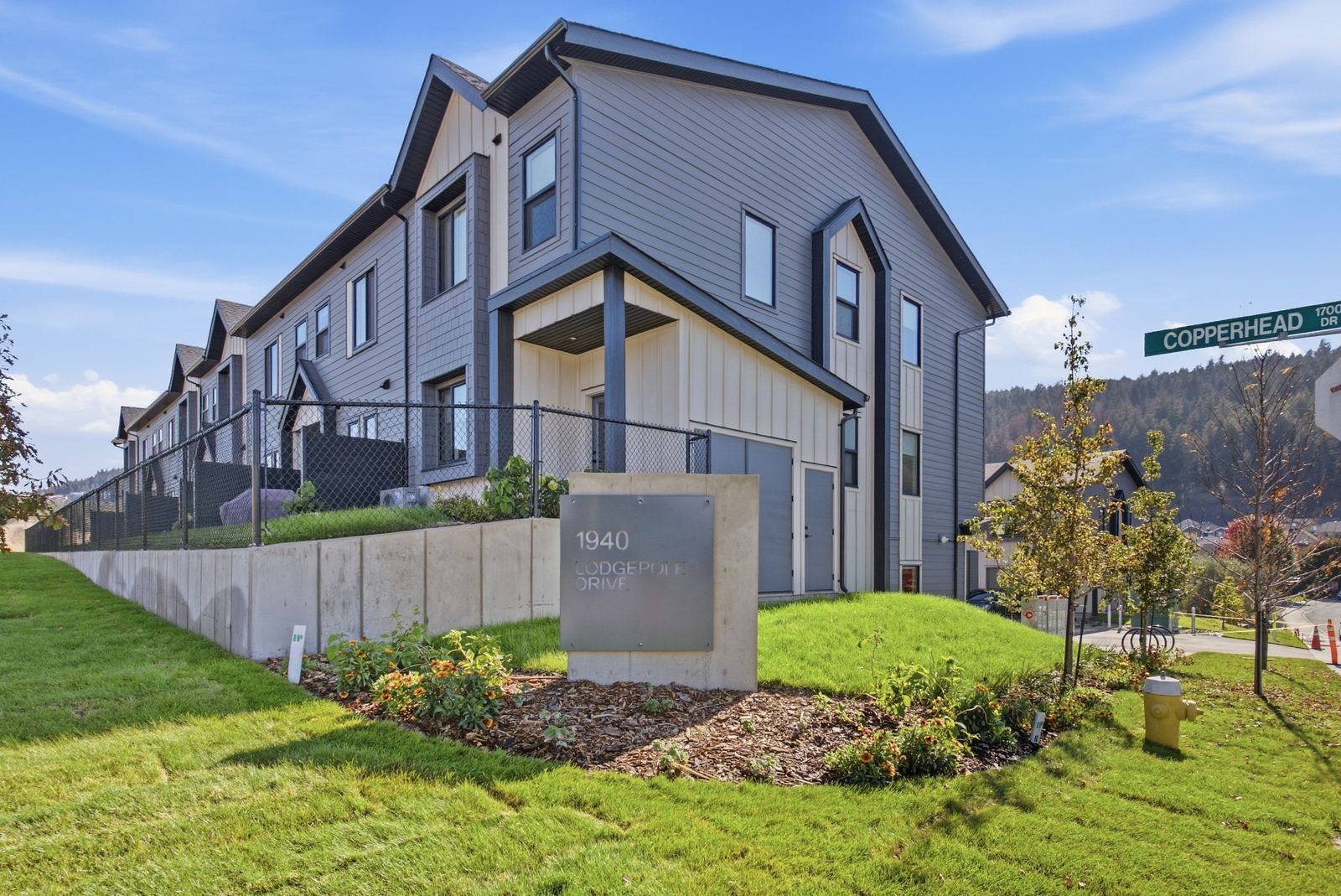 The Lodgepole Crossing entrance sign at Copperhead Drive with finished townhomes behind it