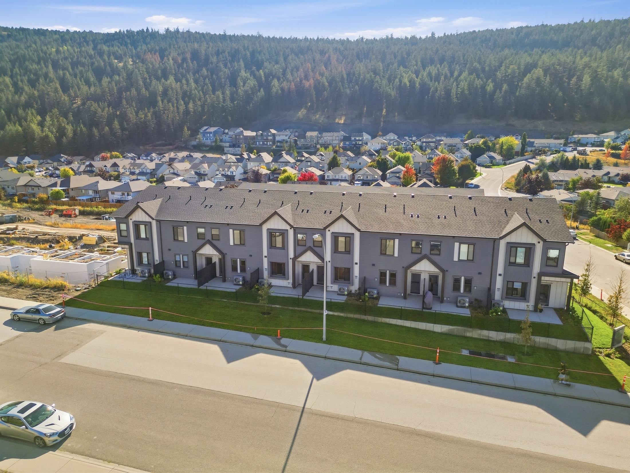 Lodgepole Crossing Phase 1 townhomes, finished and landscaped, with the forested hillside behind