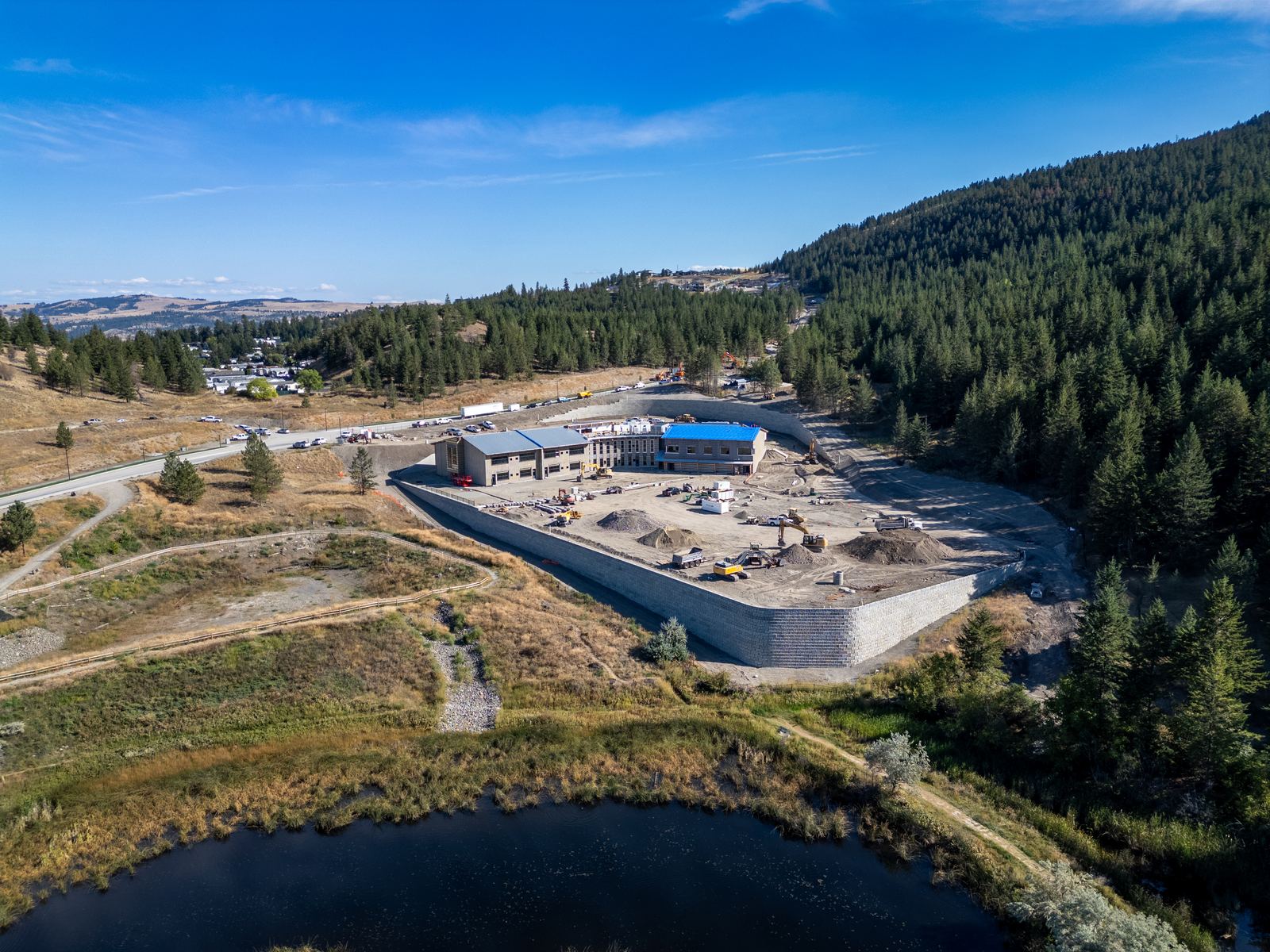 Aerial view of Sníne Elementary under construction beside a pond in Pineview Valley